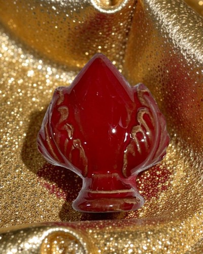 Calamita pumo rosso intenso con venature dorate su sfondo oro brillante