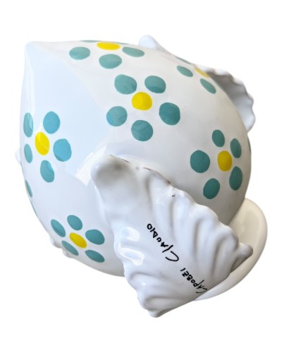 Pumo Poz Studio fiori verde Tiffany e firma Claudio Capozzi su sfondo trulli pugliesi al tramonto.