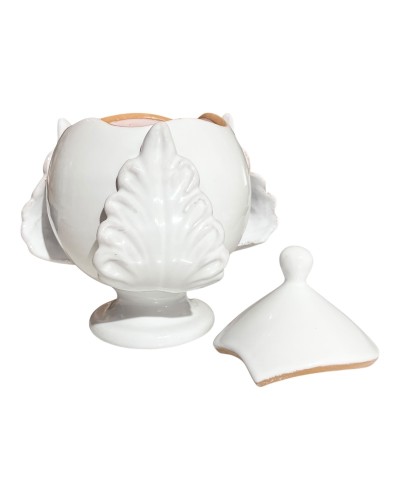 Pumo pugliese Poz Studio aperto con candela accesa e coperchio su tavolo in legno, con pomodori, olive e sfondo di uliveti.