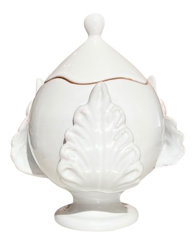 Pumo pugliese Poz Studio aperto con candela accesa e coperchio su tavolo in legno, con pomodori, olive e sfondo di uliveti.